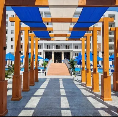 a walkway leading to a building with blue umbrellas at C'est la vie Golden in Hurghada