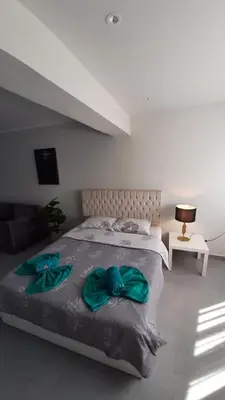 a bedroom with a bed with two green robes on it at Hurghada Ägypten Scandic Resort in Hurghada