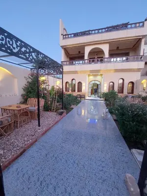 a large house with a swimming pool in front of it at Carter Guesthouse Luxor 1 in ‘Ezbet Abu Ḥabashi