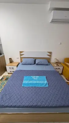 a bed with a blue blanket on top of it at Cosy Hurghada Apartments in Hurghada