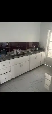 a kitchen with white cabinets and a black counter top at King mou in ‘Ezbet Abu Ḥabashi