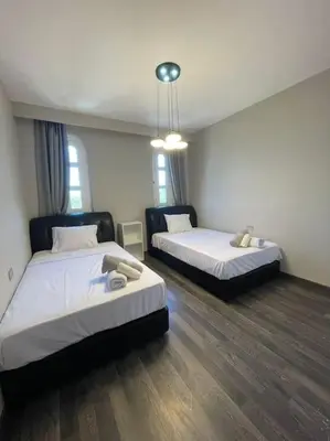 two beds in a room with wooden floors at The Sunset Heaven - 2 bedrooms - Golf Steigenberger, El Gouna in Hurghada