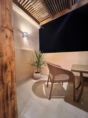 a chair and a table and a plant in a room at Komfortowy apartament na dachu w sercu miasta in Hurghada
