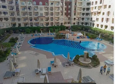 a large swimming pool in front of a large building at Chic Studio with Modern Comforts in Hurghada