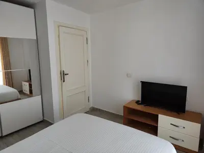 a bedroom with a bed and a flat screen tv at Stunning Rooftop 1 Bed Apartment in Hurghada