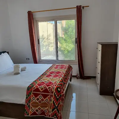 a bedroom with a bed and a large window at Almina Apartments - Come and relax with us in style in Hurghada