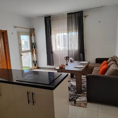 a kitchen and living room with a table and a couch at Almina Apartments - Come and relax with us in style in Hurghada