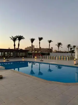 a large swimming pool with palm trees in the background at scandic in Hurghada