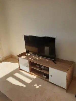 a flat screen tv sitting on top of a entertainment center at Serene Pool View 8Mins to Marina in Hurghada