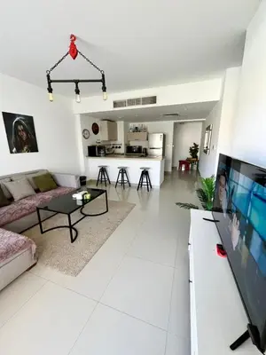 a white living room with a couch and a tv at El Gouna -G-cribs B6 in El Gouna
