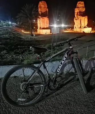 a bike parked on the side of a road at night at Al Hayat house in Luxor