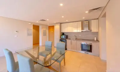 a kitchen and dining room with a glass table and chairs at Luxury Stays in Mangroovy El Gouna in Hurghada