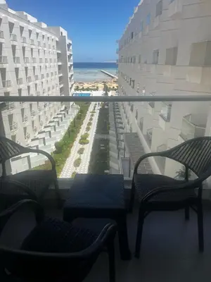 a balcony with chairs and a view of the beach at scandic resort in Hurghada