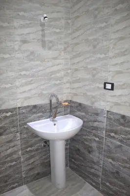 a bathroom with a white sink in a room at AL Farida Guest House in Jazīrat al ‘Awwāmīyah