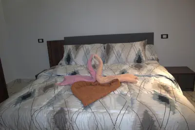 a bed with a pink flamingo and a heart at AL Farida Guest House in Jazīrat al ‘Awwāmīyah