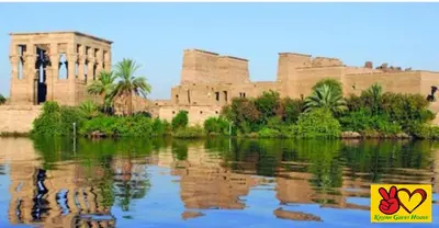 a building with its reflection in a body of water at Nubian Adventures - Felucca from Aswan to Kom Umbu in Aswan