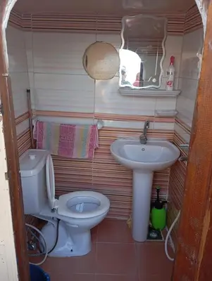 a small bathroom with a toilet and a sink at Nubian Adventures - Felucca from Aswan to Kom Umbu in Aswan