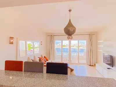 a living room with a couch and a television at Nayah Stays, Joubal Lagoons flowery apartment in Hurghada