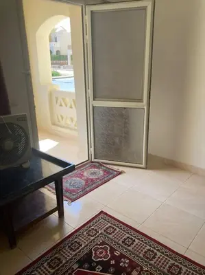 a living room with a glass door and a rug at Lovely flat with balcony and shared pool in Hurghada