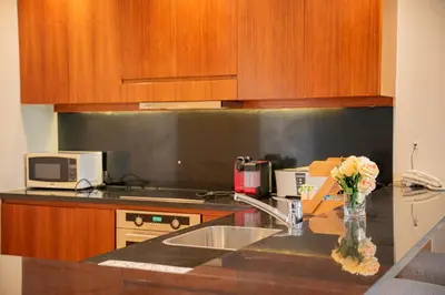 a kitchen with a vase of flowers on a counter at Nayah Stays, Ancient Sands Luxurious Pool Terrace Apartment in Hurghada