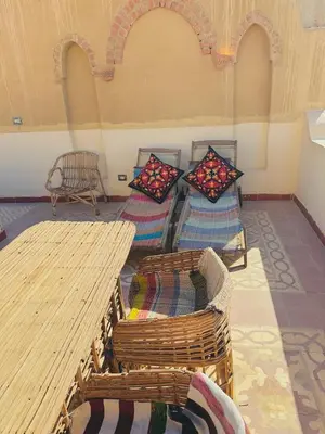 a room with two beds with pillows and a table at King Tut in Luxor