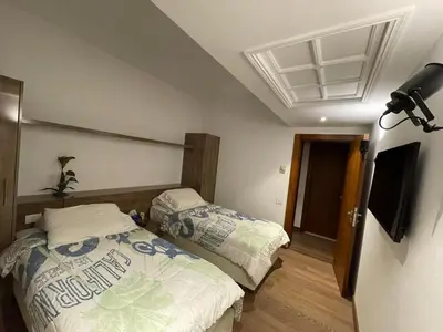 a bedroom with two beds and a television in it at Apartment for rent in ElGouna in Hurghada
