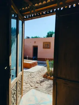 an open door to a courtyard with a building at Abou El Leef villa in Luxor