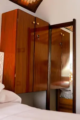 a wooden cabinet with a mirror next to a bed at dahab in Aswan