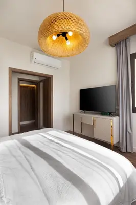 a bedroom with a large bed and a television at Fanadir Marina Front Penthouse with Pool in Hurghada