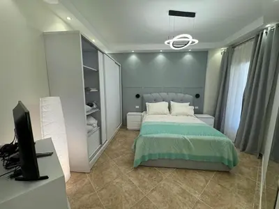a bedroom with a bed and a desk and a television at A one-bedroom apartment with a compact terrace in Hurghada