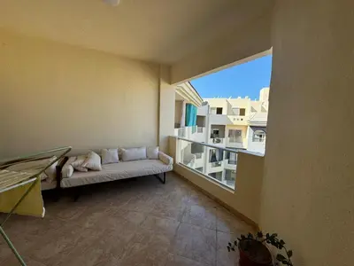 a living room with a couch and a large window at A one-bedroom apartment with a compact terrace in Hurghada