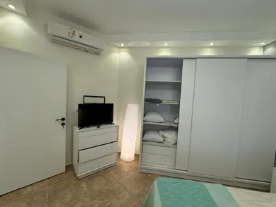 a bedroom with a bed and a tv and a closet at A one-bedroom apartment with a compact terrace in Hurghada