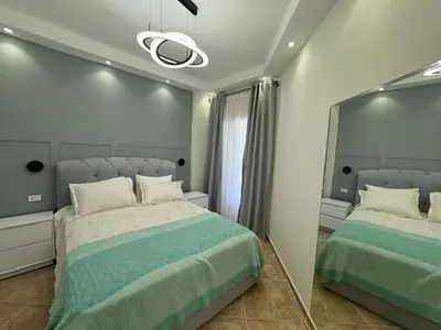 a bedroom with two beds and a mirror at A one-bedroom apartment with a compact terrace in Hurghada