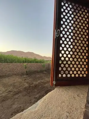 a fence with a view of a dirt field at Habu flower in Al Aqālitah