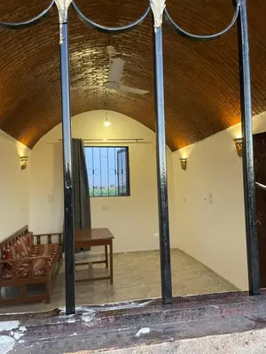 a room with a wooden ceiling and a table and chairs at Habu flower in Al Aqālitah