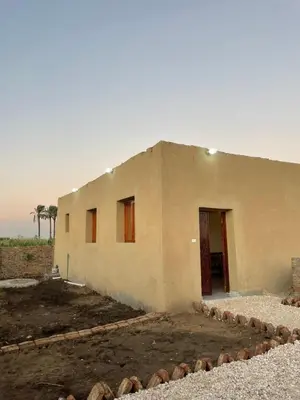 a building in the middle of a field at Habu flower in Al Aqālitah