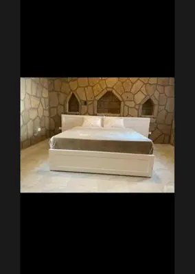 a large bed in a room with a stone wall at Villa Nile Queen -guest house in Luxor