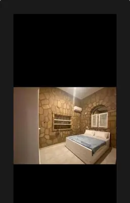 a bedroom with a bed in a stone wall at Villa Nile Queen -guest house in Luxor