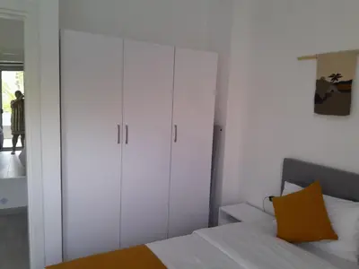 a bedroom with white cabinets and a bed with a yellow pillow at Spacious and modern one bed in hurhgarda in Hurghada