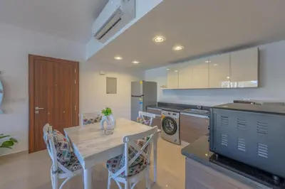 a kitchen with a table and chairs and a refrigerator at Chic 2 BR poolside Apartment at G-crib El Gouna in Hurghada
