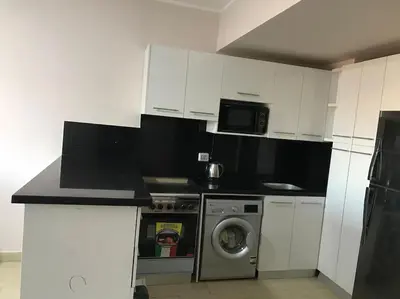 a kitchen with a washing machine and a microwave at Al Dau Heights in Hurghada