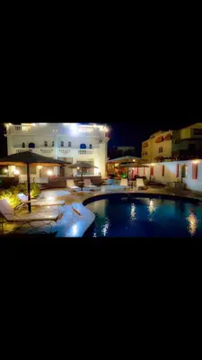 a large pool in front of a building at night at C and S park in Hurghada