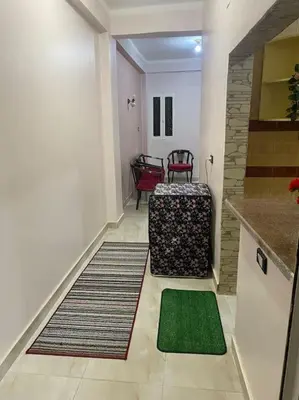 a hallway with a living room with a green rug at Steven in Luxor