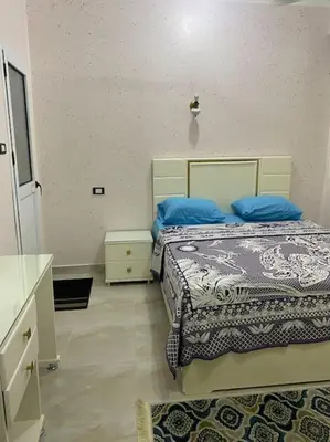 a bedroom with two beds with blue pillows at Steven in Luxor