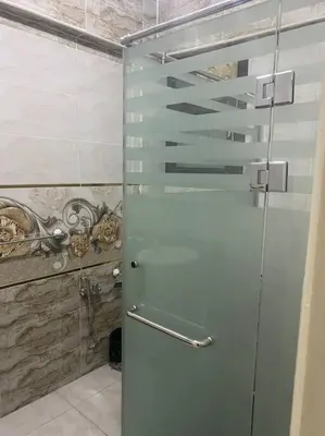 a shower with a glass door in a bathroom at Just the two of us in Luxor