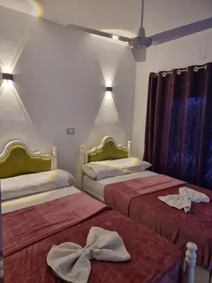 two beds in a room with towels on them at PANORAMIC BABA DOoL in Aswan