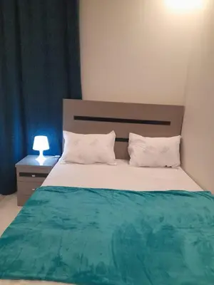a bedroom with a bed with a green and white blanket at Wadjet-inn in Hurghada