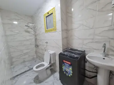 a white bathroom with a toilet and a sink at Mabed in Hurghada