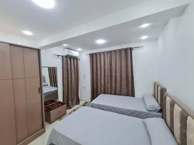 a small bedroom with two beds and a mirror at Mabed in Hurghada