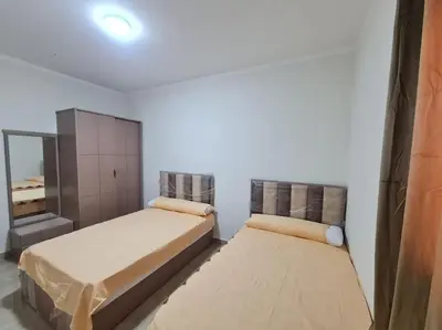 a bedroom with two beds and a mirror at Golden Home in Hurghada